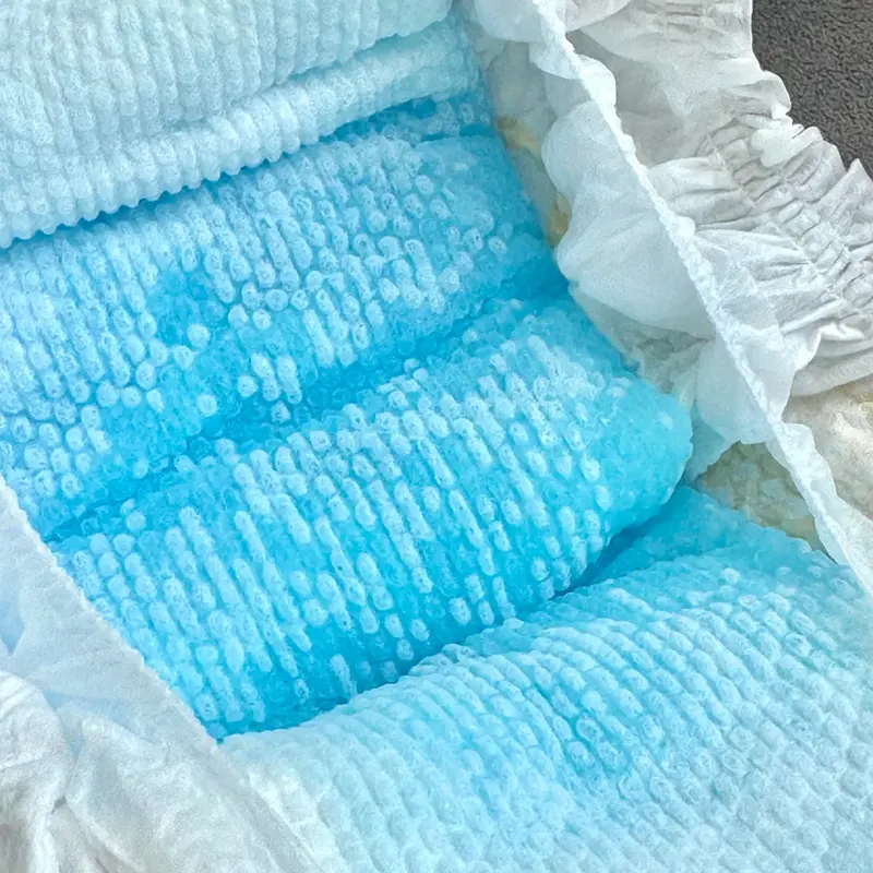 Hand holding topsheet emboss sample — pearl dot pattern