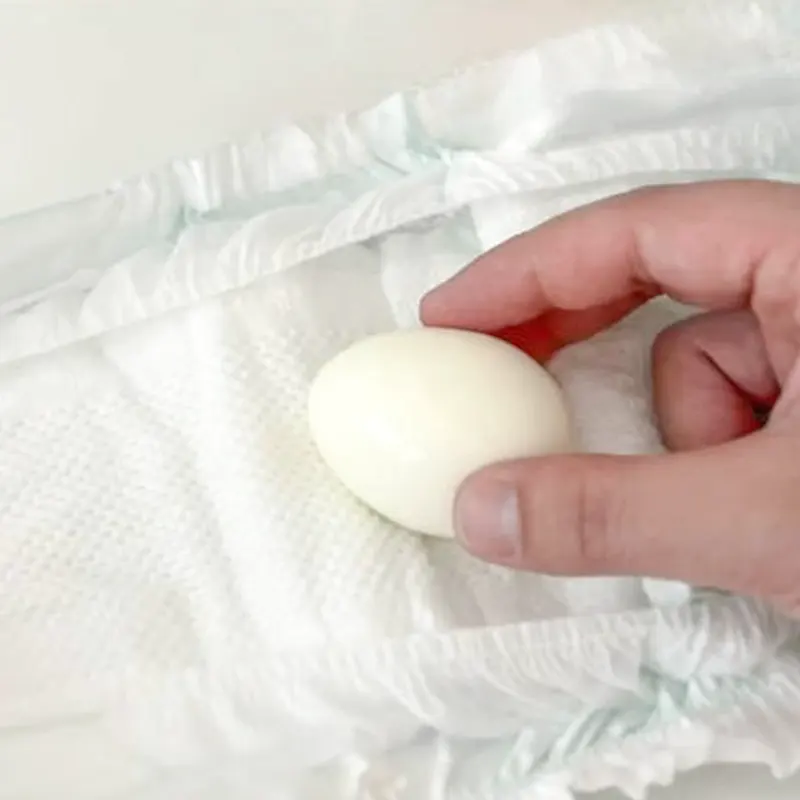 Hand rolling a peeled egg on the diaper’s topsheet—no scuffing, low friction