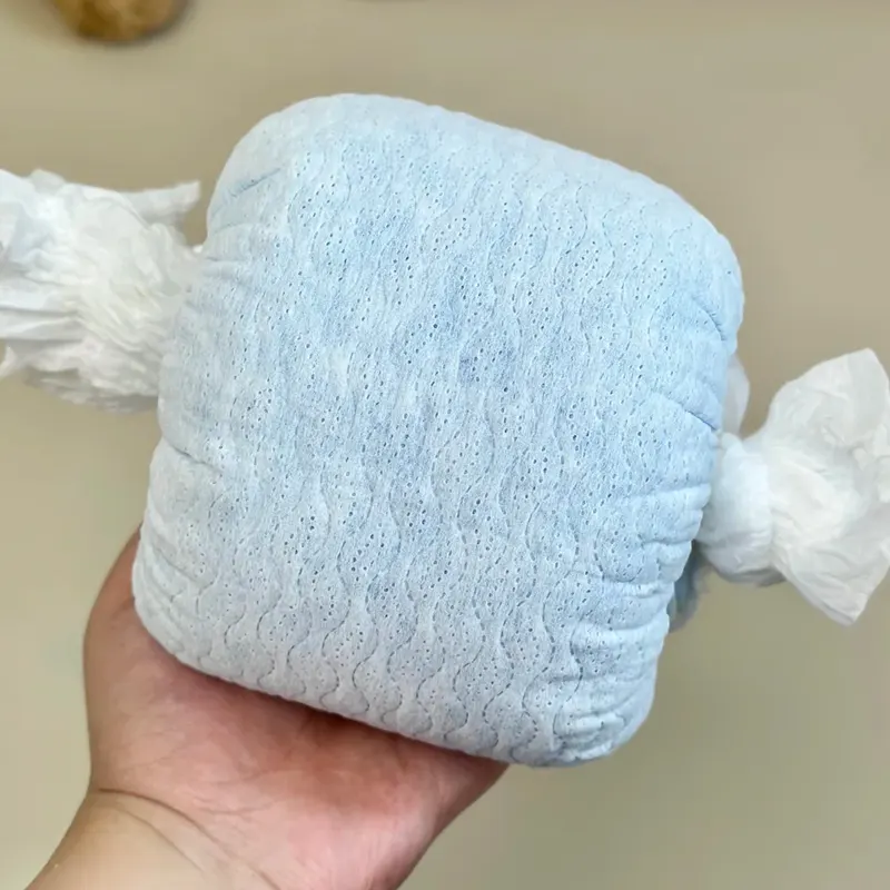 Hand holding a wet diaper showing an intact, bonded SAP core—no core break, clumping, or sagging.