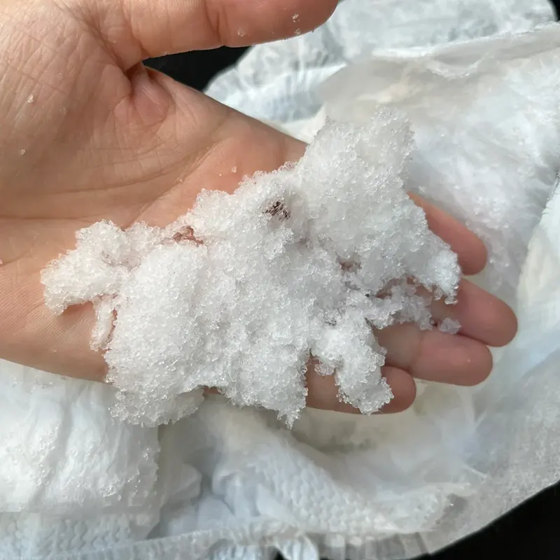 Soaking slice of diaper made of natural wood pulp+SAP covered on top with white porous layer.