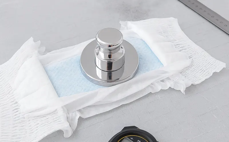Rewet test: weight pressing the diaper core while the topsheet stays dry.