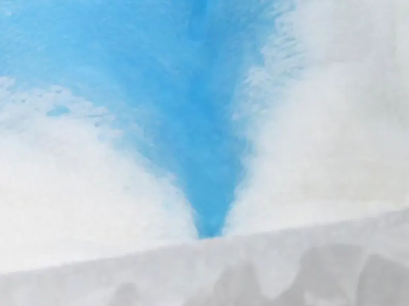Blue liquid quickly guided into diaper core demonstrating 3D leak-guard channels.